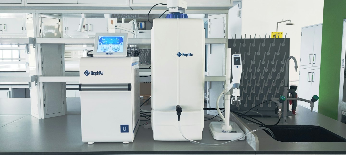 Scientific laboratory workstation with Rephile water purification equipment and a sink.